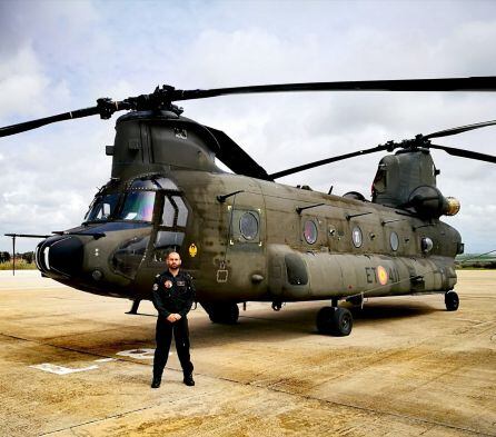 Iván Vozmediano posa junto a uno de los helicópteros que ha pilotado