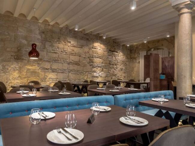 Comedor con varias confituraciones de mesas y piedra de las antiguas caballerizas