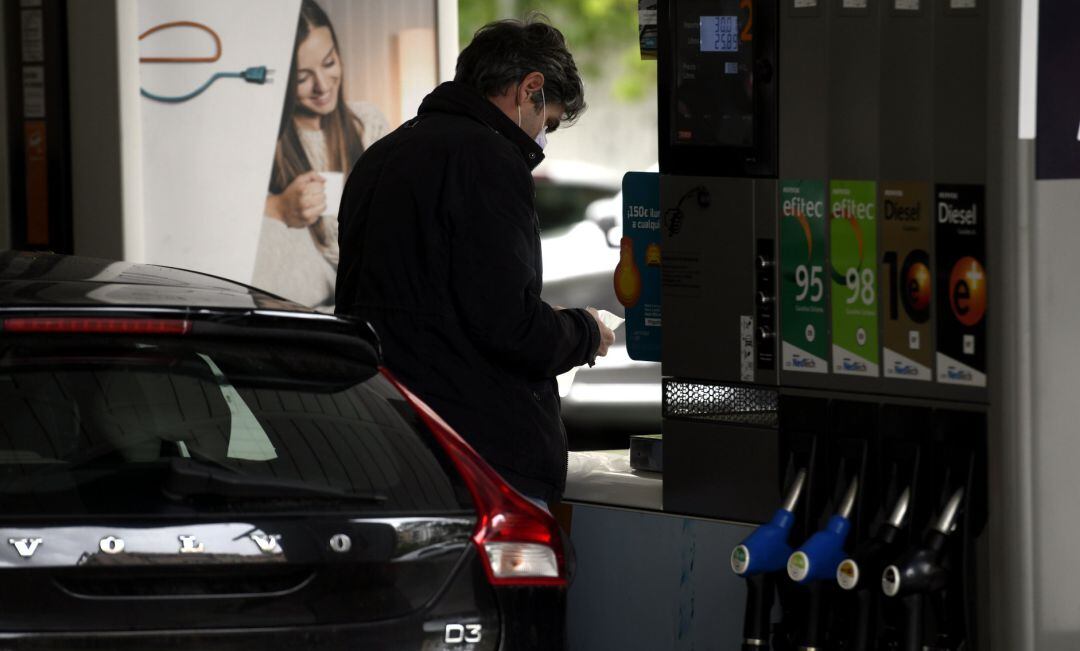 Un hombre echa gasolina a su coche en una gasolinera.