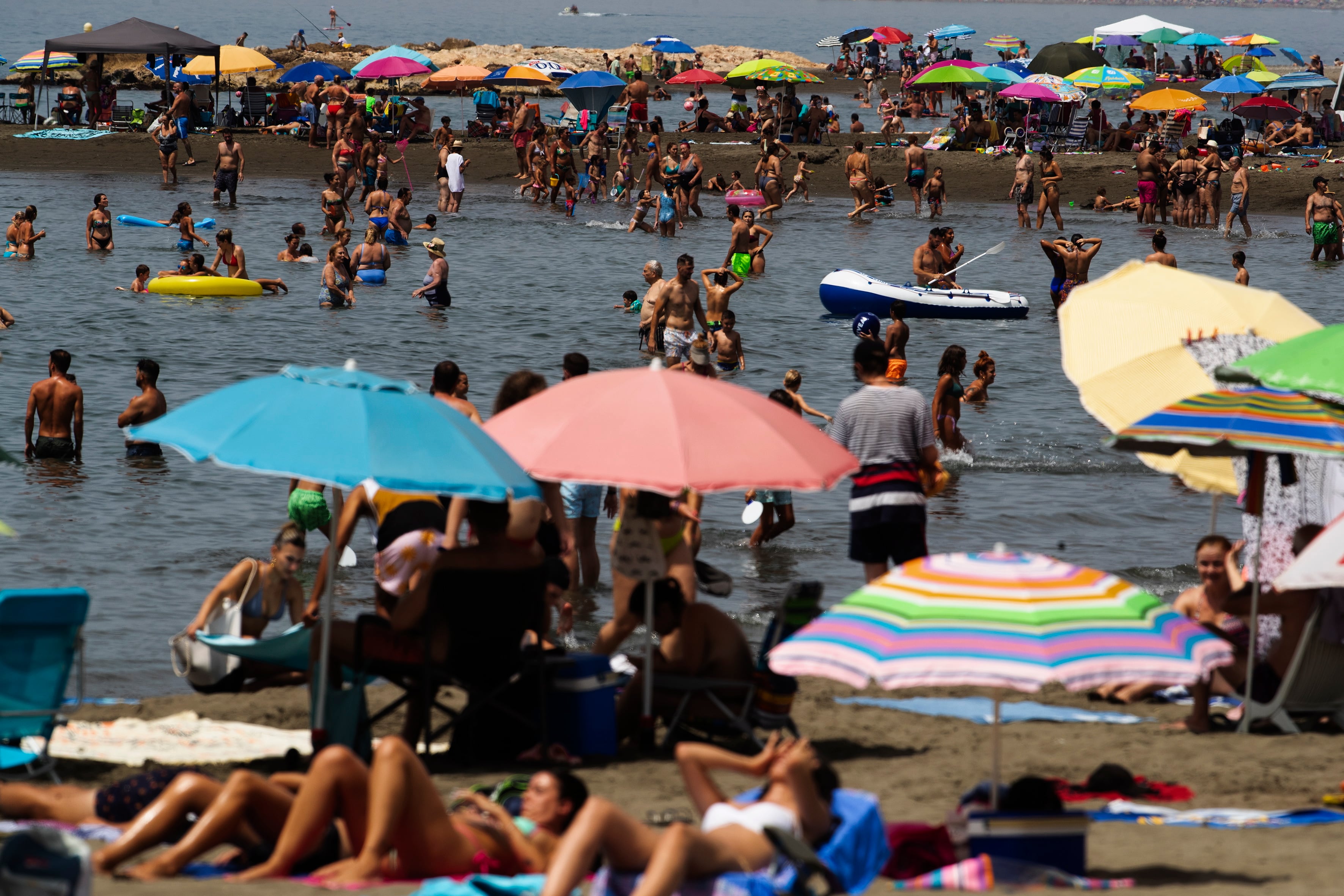 Numerosas personas llenan la playa del Palo de Málaga.