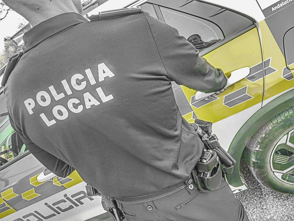 Un agente de la Policía Local de Jaén delante de un vehículo policial