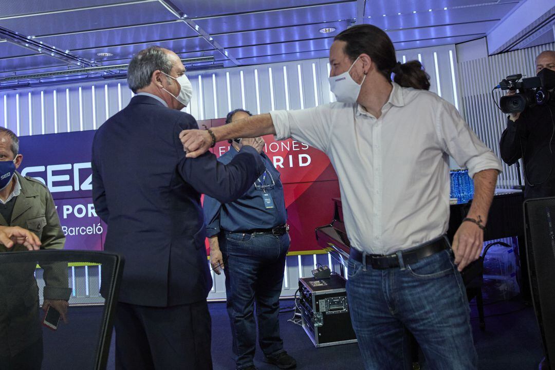 El candidato del PSOE, Ángel Gabilondo (i); y el candidato de Unidas Podemos a la Presidencia de la Comunidad de Madrid, Pablo Iglesias; se saludan con el brazo minutos antes de que de comenzara el debate organizado por la SER.