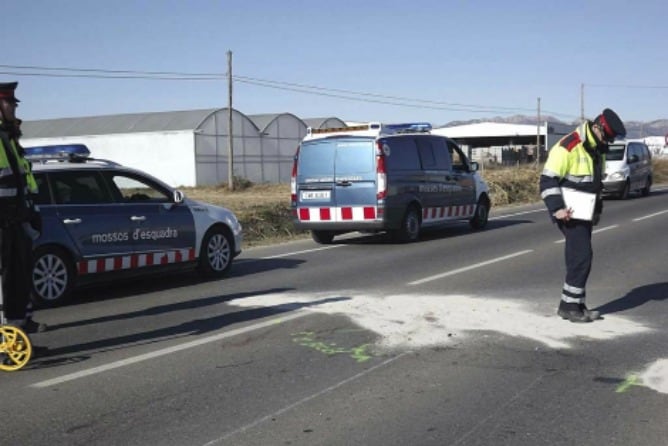 Un agente observa el lugar donde fueron arrollados los ciclistas en Vallfogona de Balaguer en 2012