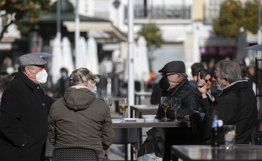 Cuatro personas en la terraza de un bar.