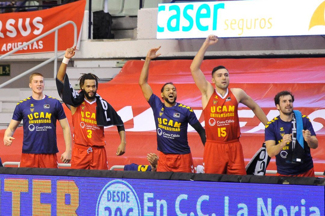 Parte de la plantilla y cuerpo técnico del UCAM animando en el banquillo