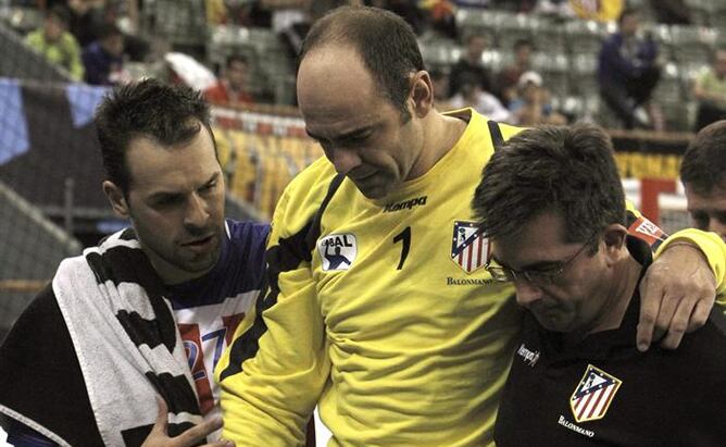 El portero del Atlético de Madrid José Javier Hombrados (c) abandona la pista tras lesionarse en el partido correspondiente a la tercera jornada de la fase de grupos, Grupo B, de la Liga de Campeones de Balonmano, que han disputado frente al MKB Veszprém 