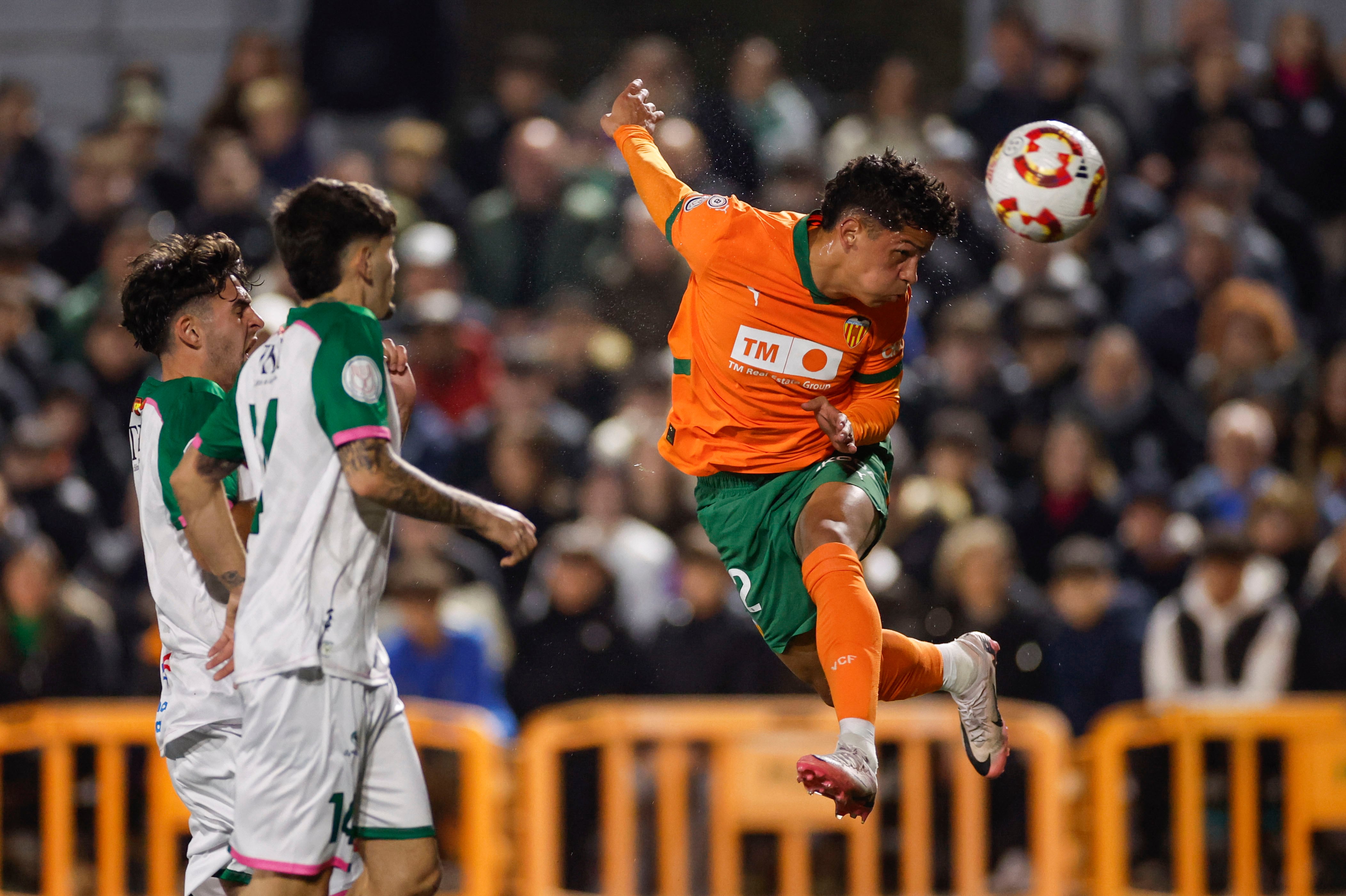 MADRID, 26/11/2024.- El extremo costarricense del Valencia Warren Madrigal (d) remata un balón durante el encuentro de la Copa del Rey disputado este martes entre el CP Parla Escuela y el Valencia CF en el estadio Las Américas de Madrid. EFE/ Sergio Pérez
