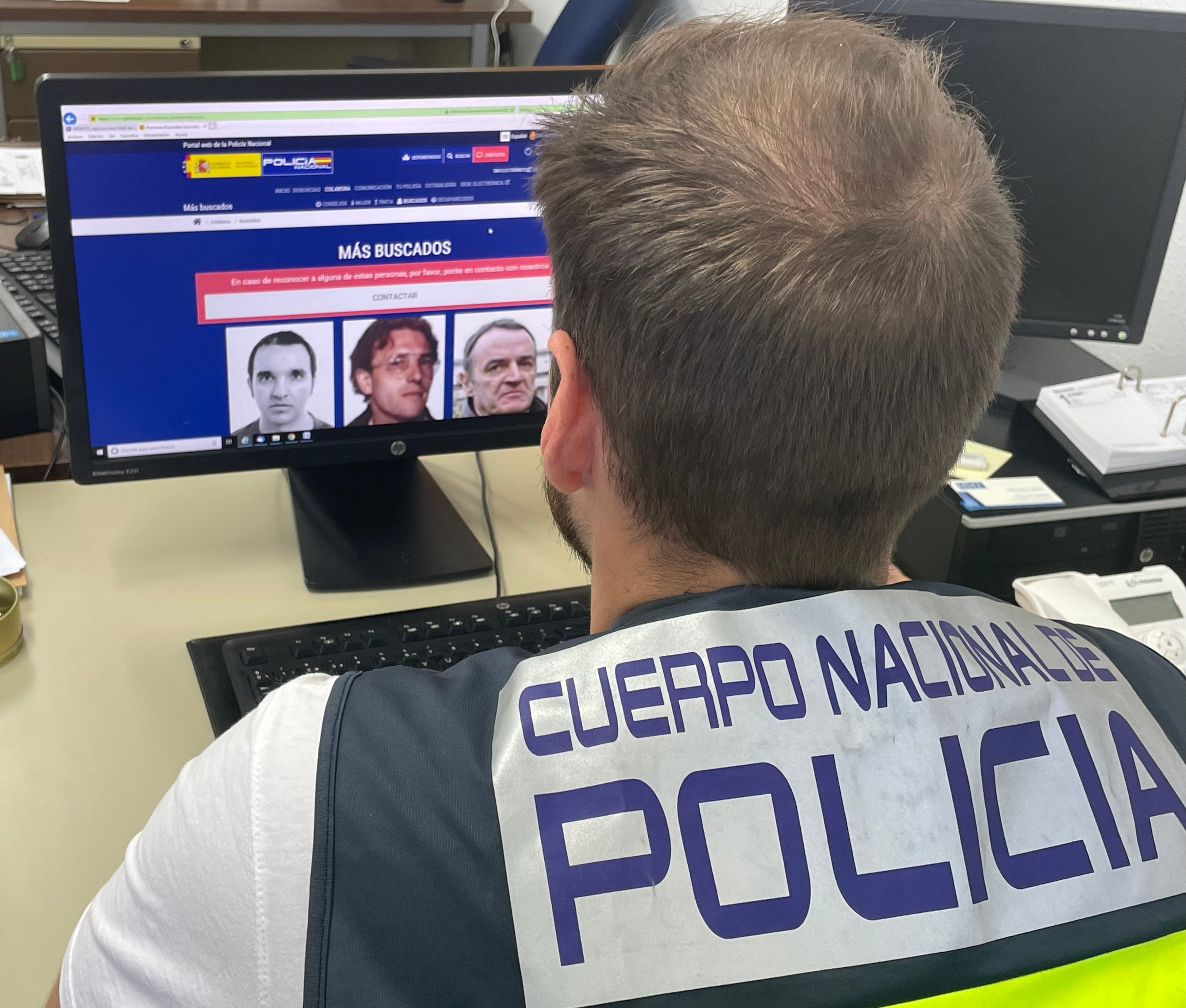 Un agente revisa las fotografías de los delincuentes más buscados por Interpol