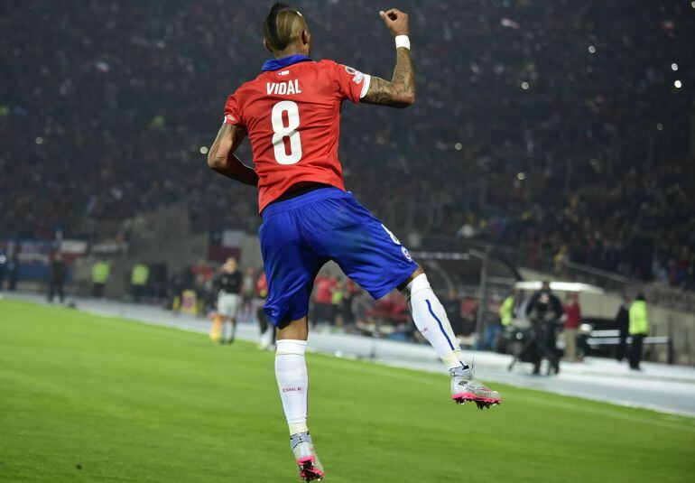 Chile&#039;s midfielder Arturo Vidal celebrates after scoring a penaly kick against Ecuador during the Copa America inauguration football match at the Nacional stadium in Santiago, on June 11, 2015. AFP PHOTO / LUIS ACOSTA