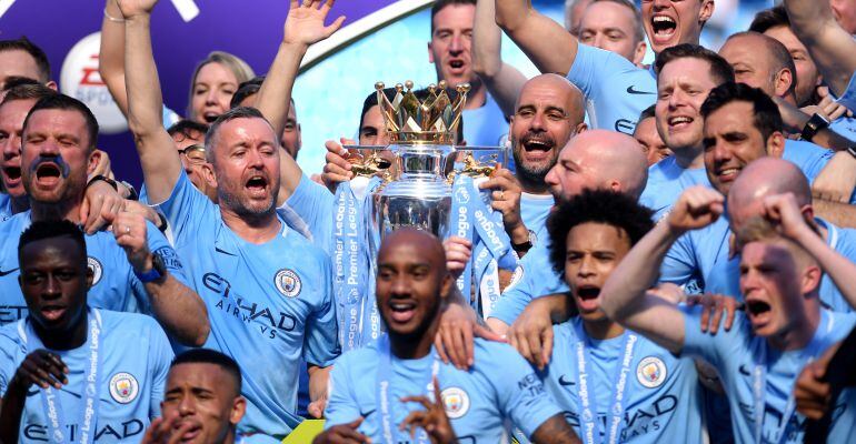 Pep Guardiola sostiene el trofeo que acredita al Manchester City como campeón de la Premier League