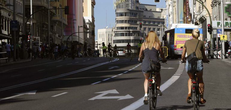 GRA178 MADRID, 22/09/2015.- Dos mujeres recorren en bicicleta la Gran Vía de Madrid cerrada al tráfico con motivo del Día Sin Coches que, además de Madrid, celebran Valladolid, San Sebastián, y Valencia, entre 330 ciudades, con acciones que van desde limitar el tráfico privado en algunas áreas y franjas horarias a ofrecer transporte público gratuito o reducir la velocidad para &quot;pacificar&quot; el ambiente urbano. EFE/Mariscal