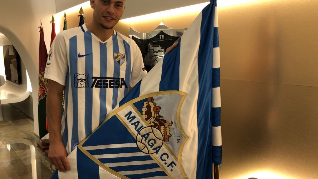 Rahmani posa con la bandera del málaga tras firmar