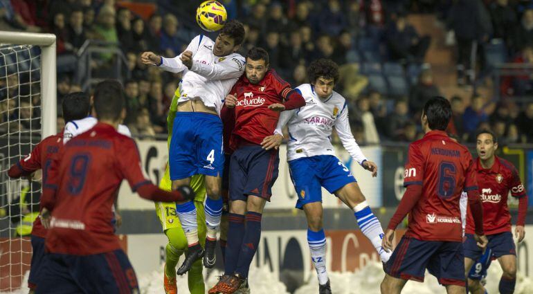 GRA489. PAMPLONA, 10/02/2015.- El jugador de Osasuna, Miguel Flaño (c), disputa un balón a los jugadores del Real Zaragoza, Cabrera (i), Mario Abrante (d) durante el partido que ha enfrentado esta tarde a ambos en el estadio de El Sadar correspondiente a