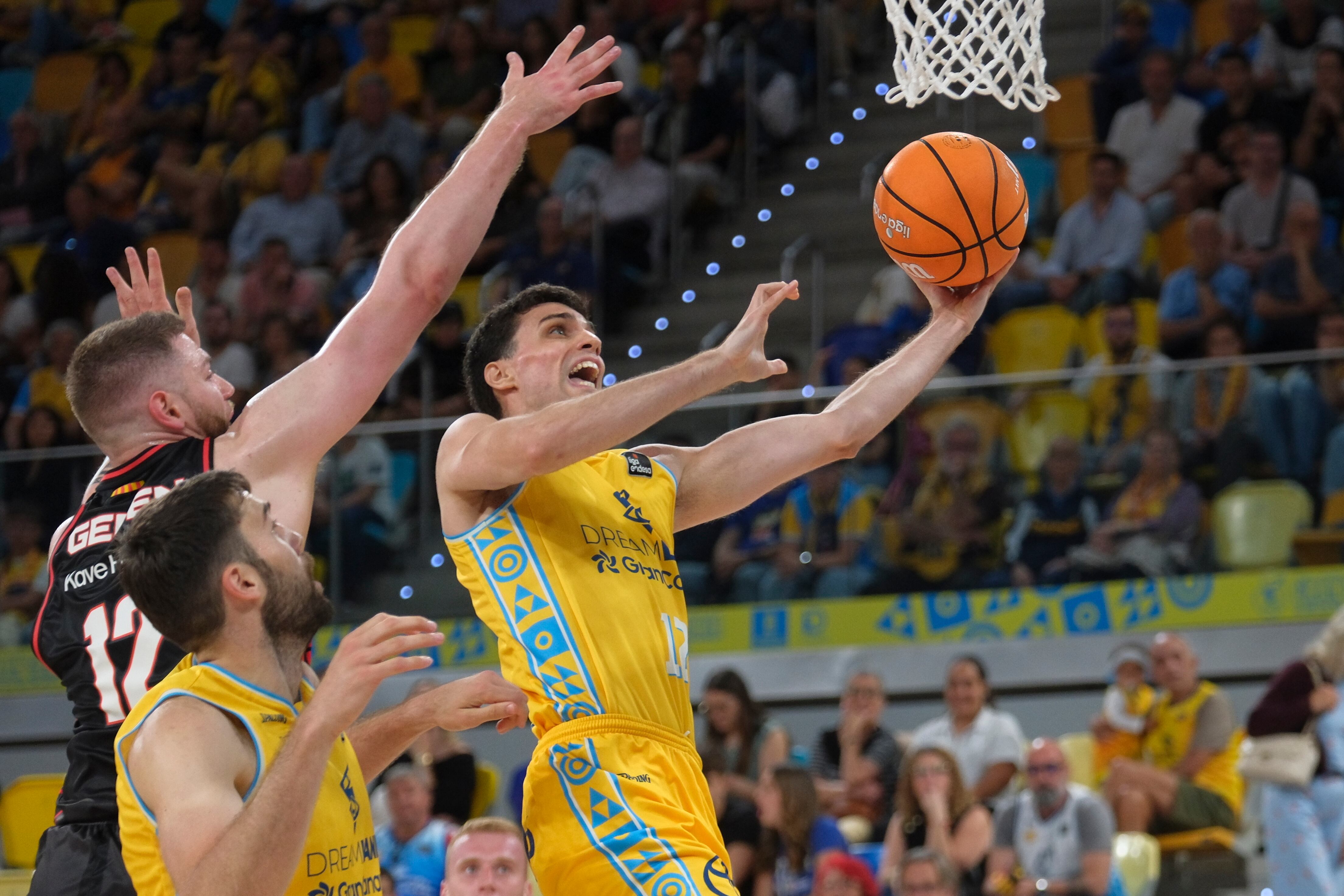 LAS PALMAS DE GRAN CANARIA, 25/04/2026.- El base del Gran Canaria Carlos Alocen (d) entra a canasta defendido por el lituano Martinas Geben (i), del Basquet Girona, durante el encuentro de la Liga Endesa entre Gran Canaria y Bàsquet Girona, este sábado en el Gran Canaria Arena de Las Palmas de Gran Canaria. EFE/ Ángel Medina G.