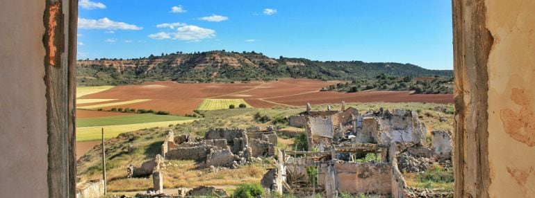 Casas derruidas en Villalbilla con el paisaje alcarreño al fondo.