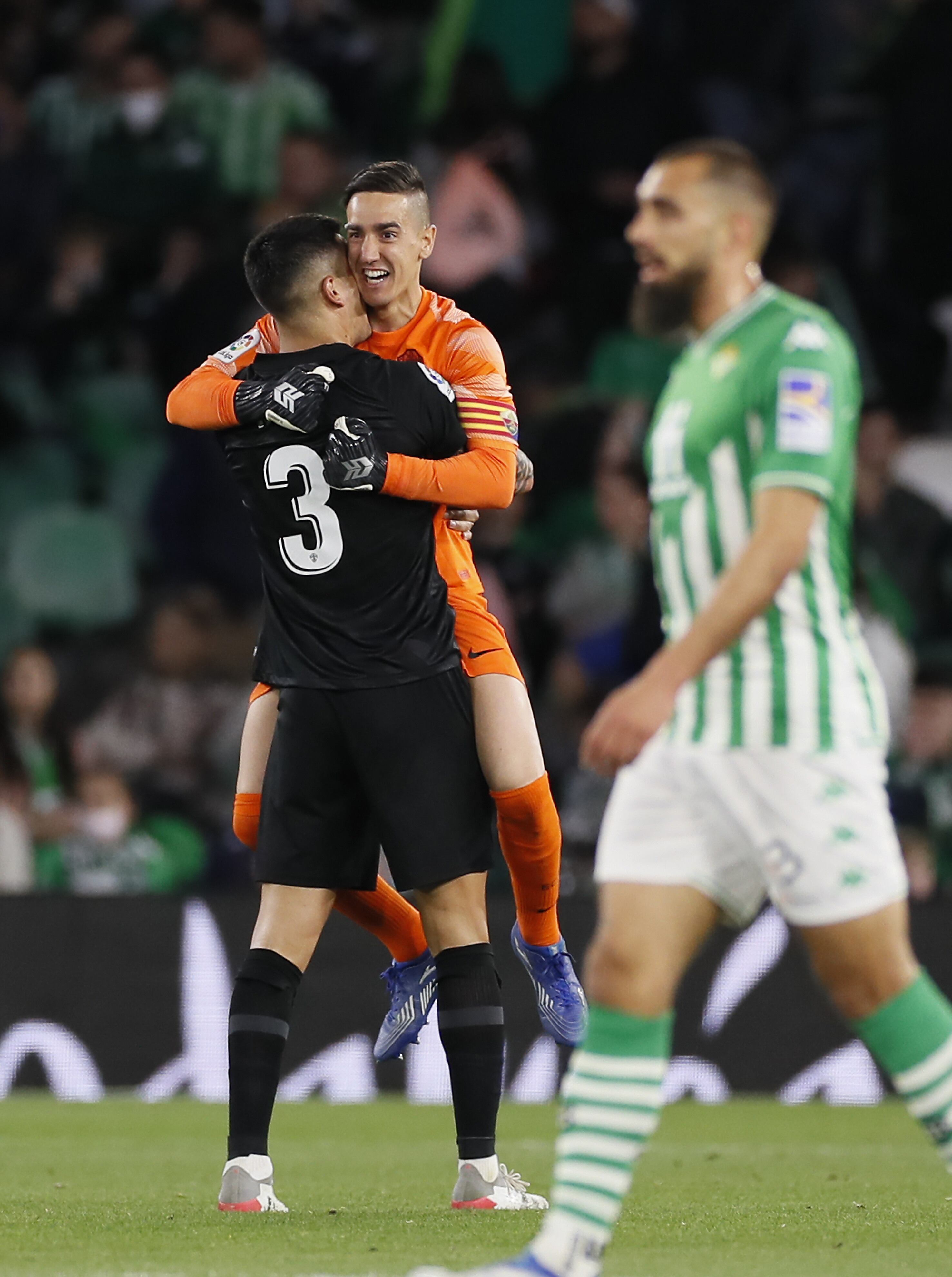 SEVILLA, 19/04/2022.- Los jugadores del Elche, el chileno Enzo Roco y Edgar Badia, celebran su victoria a la finalización del encuentro de la jornada 33 de Liga en Primera División que han disputado hoy martes frente al Betis en el estadio Benito Villamarín, en Sevilla. EFE/José Manuel Vidal.
