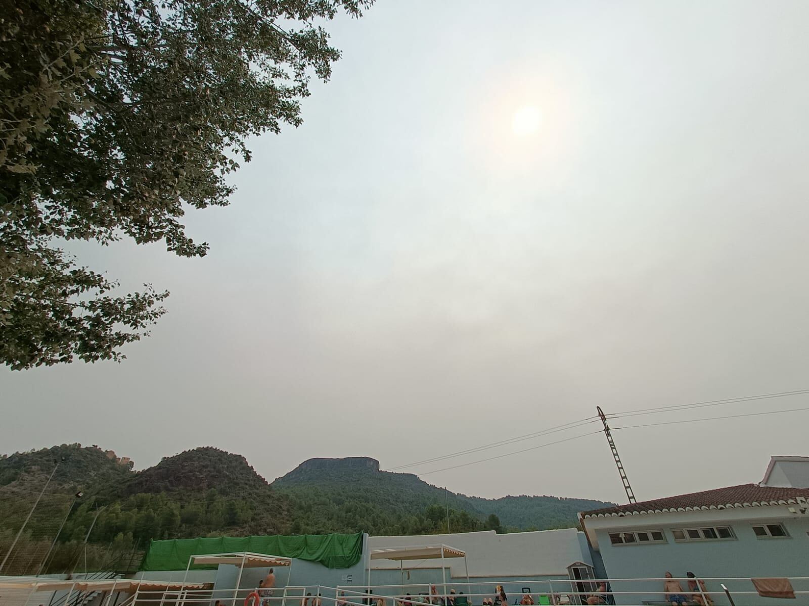 El cielo se tiñe de un color blanquecino por la presencia de humo y polvo en capas altas.