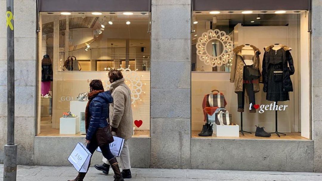 Dues dones mirant botigues.