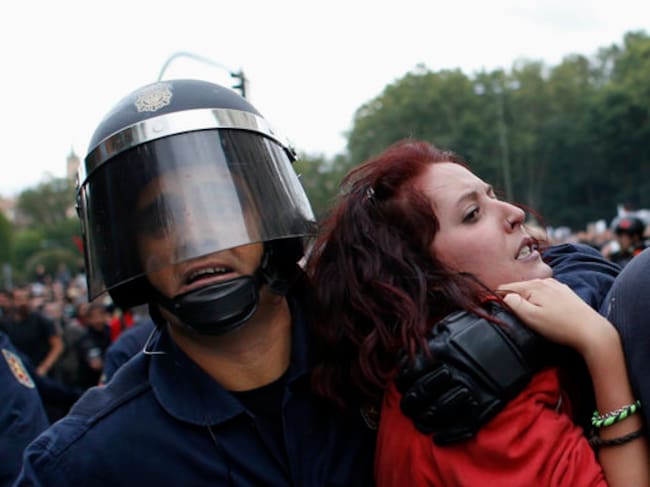 Una manifestante es arrastrada por la policía