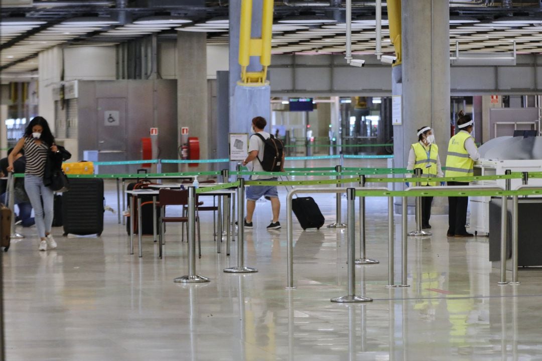 Pasajeros procedentes de Londres caminan entre los pasillos delimitados, antes de rellenar un formulario, a su llegada al Aeropuerto de Madrid-Barajas Adolfo Suárez