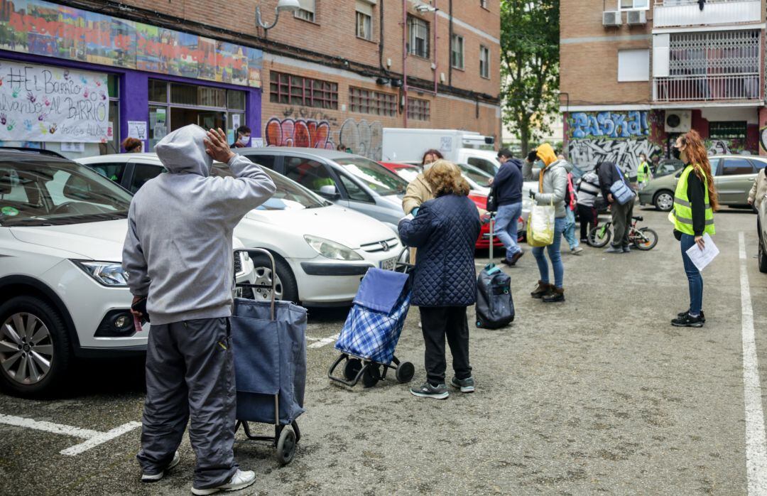 Vecinos de Aluche (Madrid) esperan en cola para recoger bolsas de alimentos de la Asociación de Vecinos Parque Aluche, una imagen que se repite en todo el país.