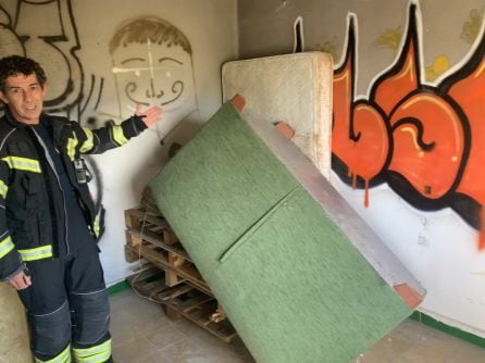 El jefe del equipo de Bomberos de Ponferrada, Olivier Bao, explica a los medios los detalles de la combustión de la estancia que incendiarán para ver el comportamiento del fuego real