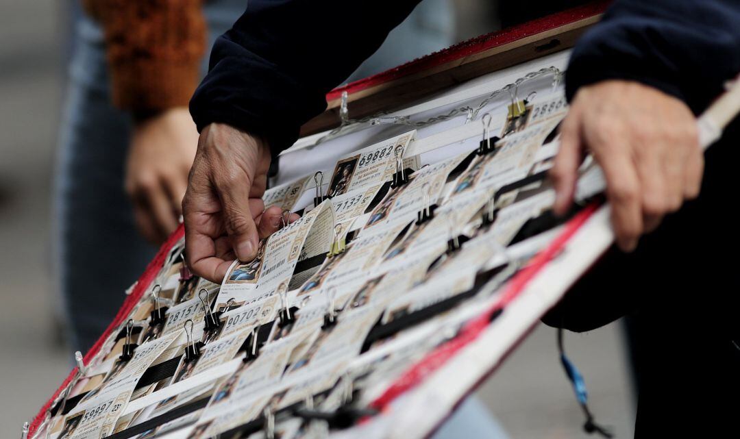 Panel con los boletos de Lotería de Navidad que vende un lotero en la Plaza del Sol de Madrid.