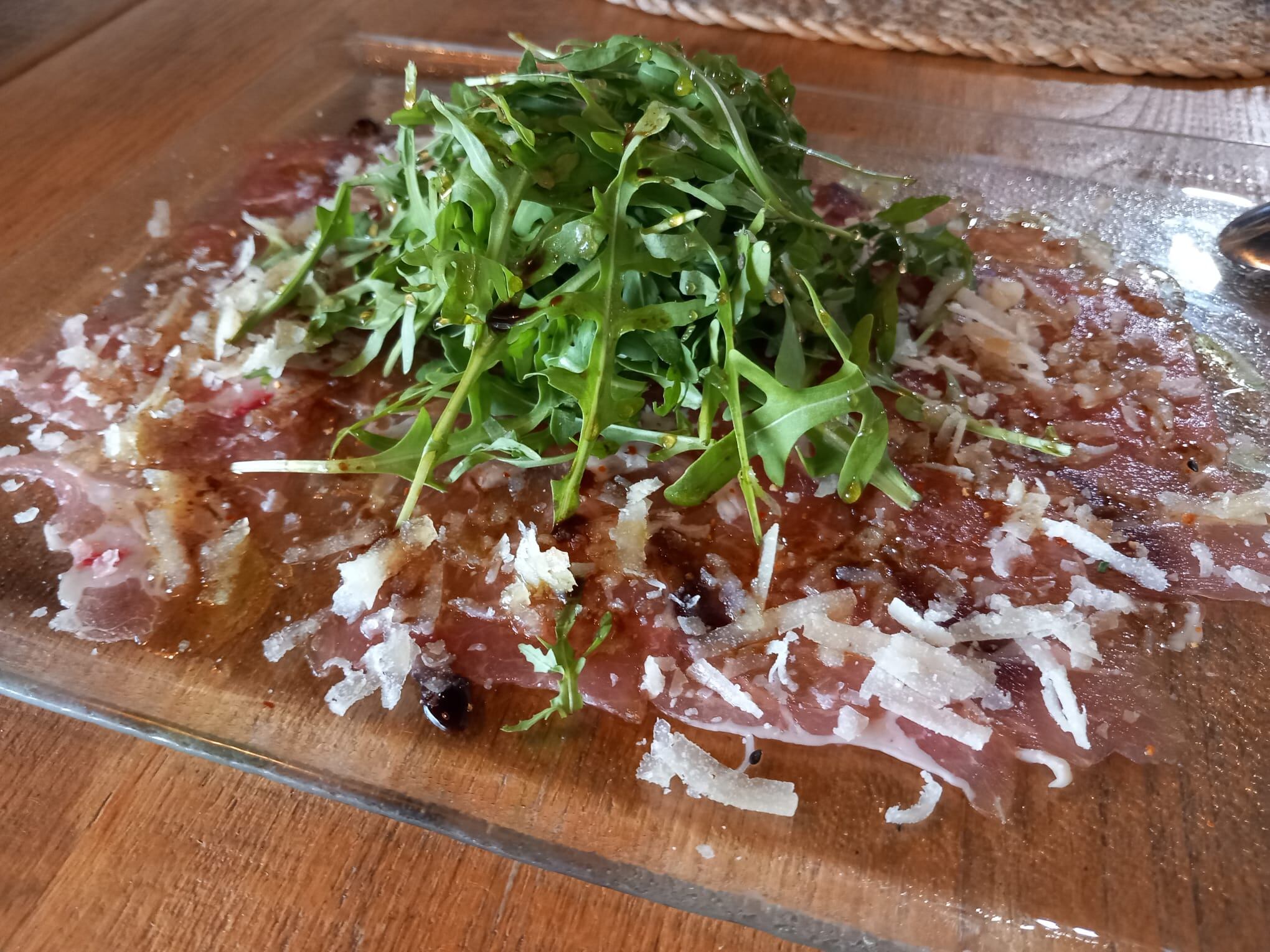 Carpaccio de presa ibérica con parmesano y rúcula