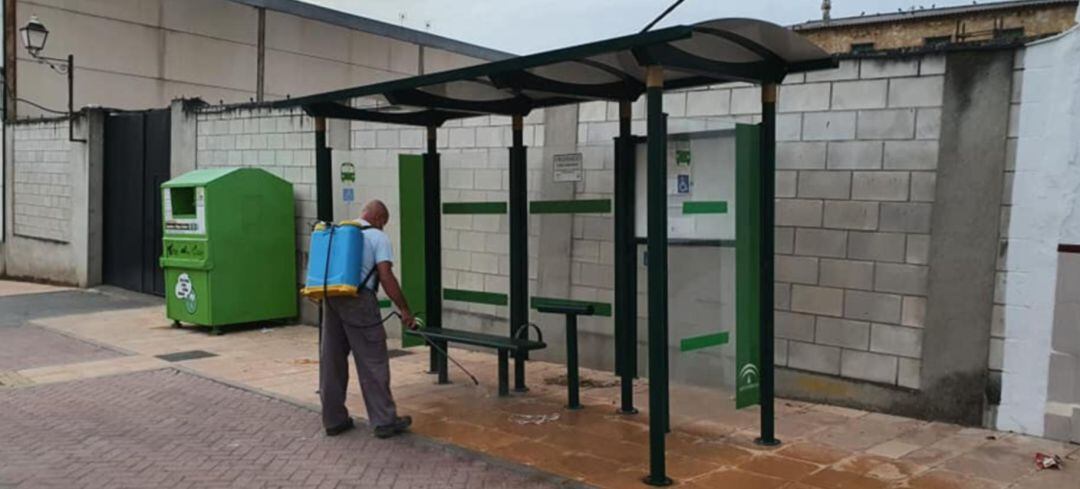 Un operario desinfecta una marquesina en Lahiguera.