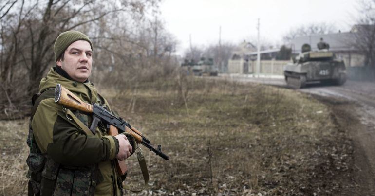 Un rebelde prorruso monta guardia durante el repliegue de armamento pesado en la localidad fronteriza de Olenivka, Donetsk, Ucrania