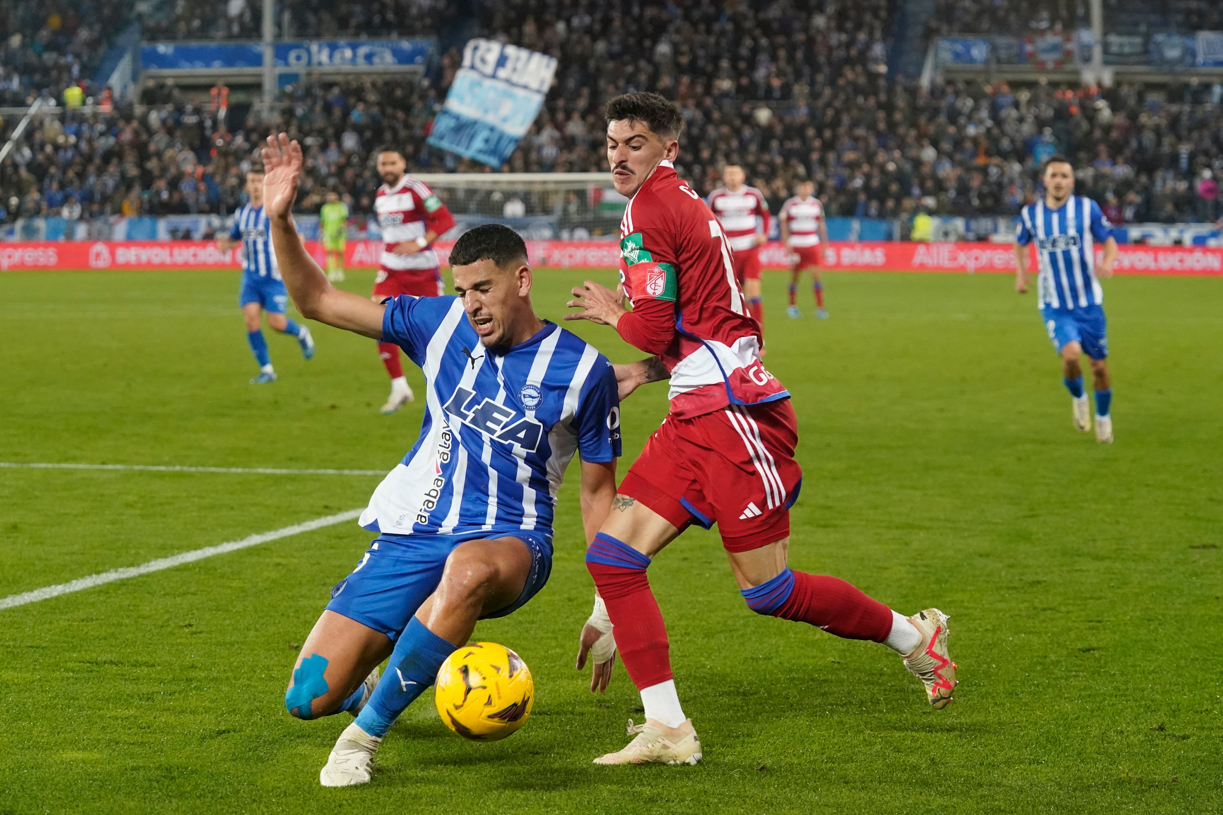 Abdel Abqar, del Deportivo Alavés, trata de frenar el avance de Carlos Neva en un partido contra el Granada. EFE/ADRIAN RUIZ HIERRO