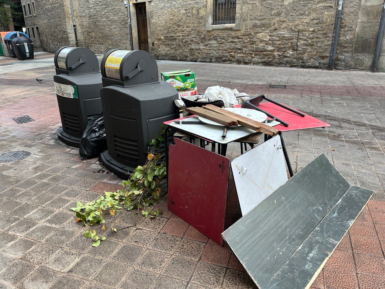 Restos del mobiliario de los bares en la basura tras los altercados del domingo en Vitoria.