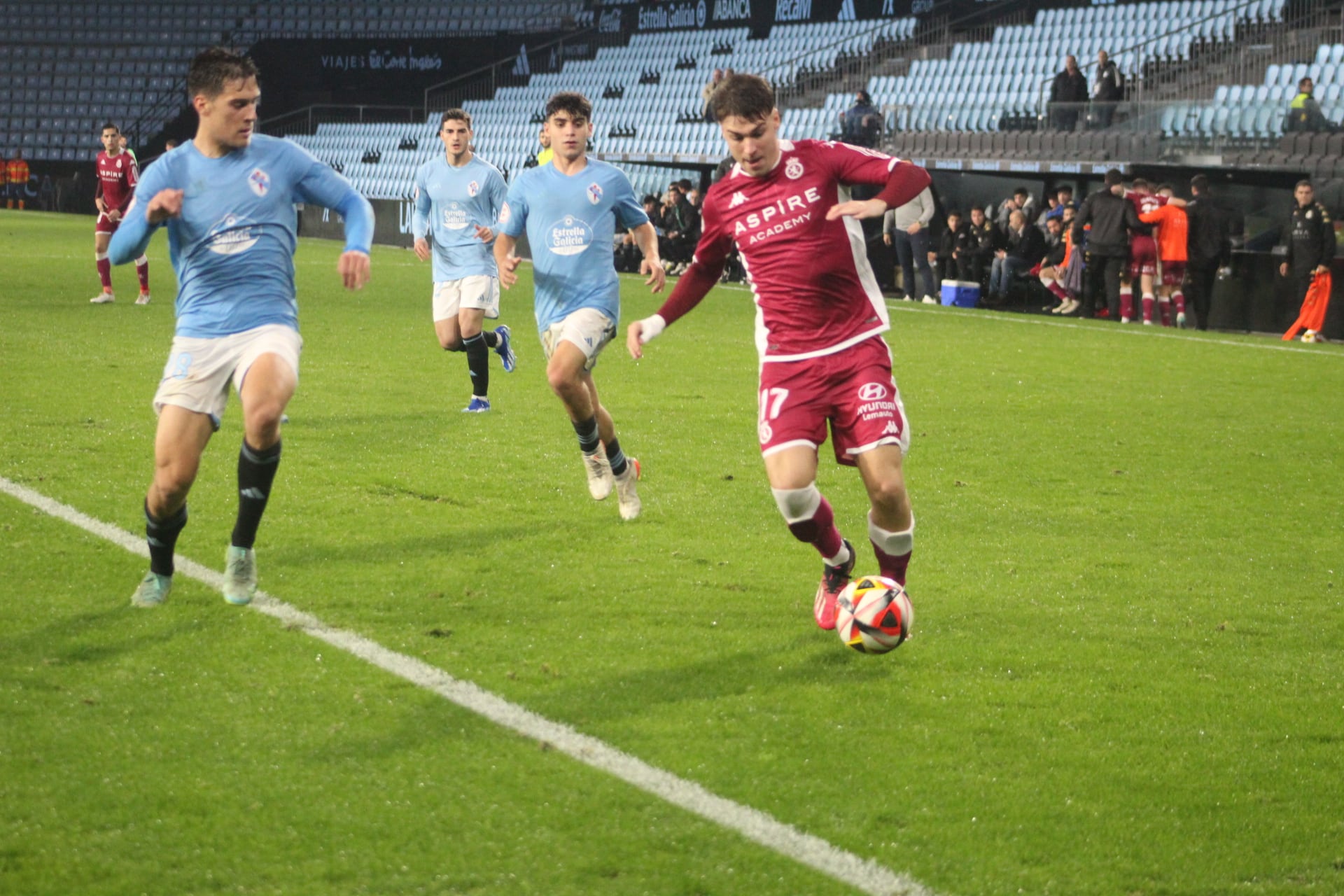 Álvaro conduce el balón ante un defensa del Celta B / Isaac Llamazares