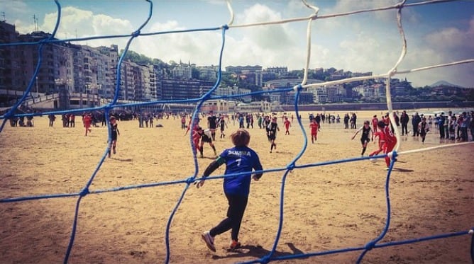 Niños jugando a fútbol en la playa de La Concha