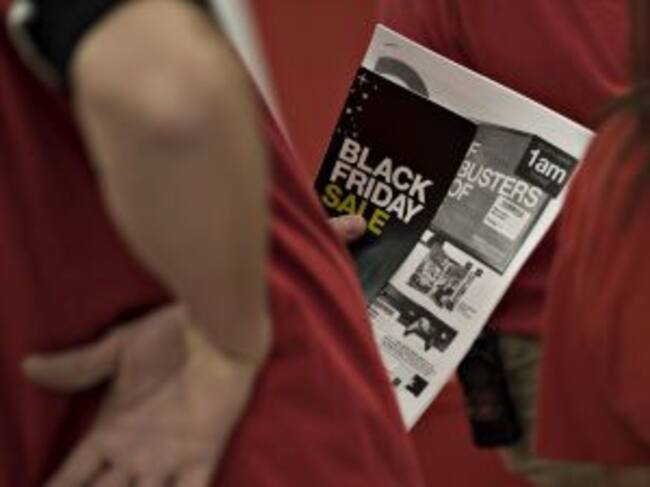 El empleado de una tienda sujeta un folleto del Black Friday