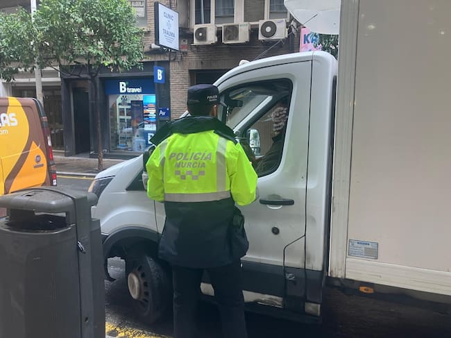 Un agente de la Policía Local de Murcia advierte a un transportista de que no está haciendo uso correctamente del espacio de carga y descarga en la calle Alejandro Seiquer