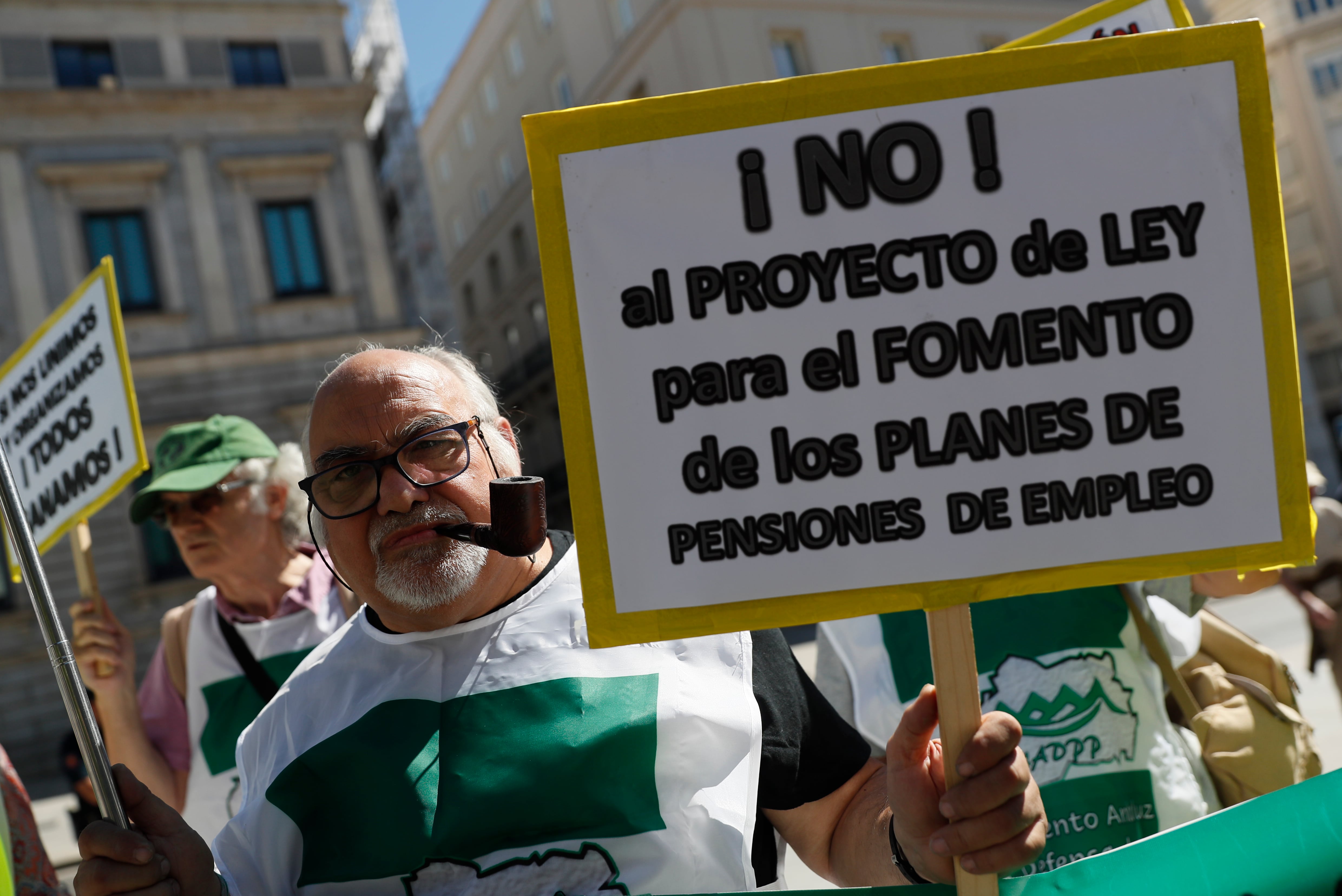 Un hombre muestra una pancarta durante la manifestación de varias plataformas y movimientos de pensionistas