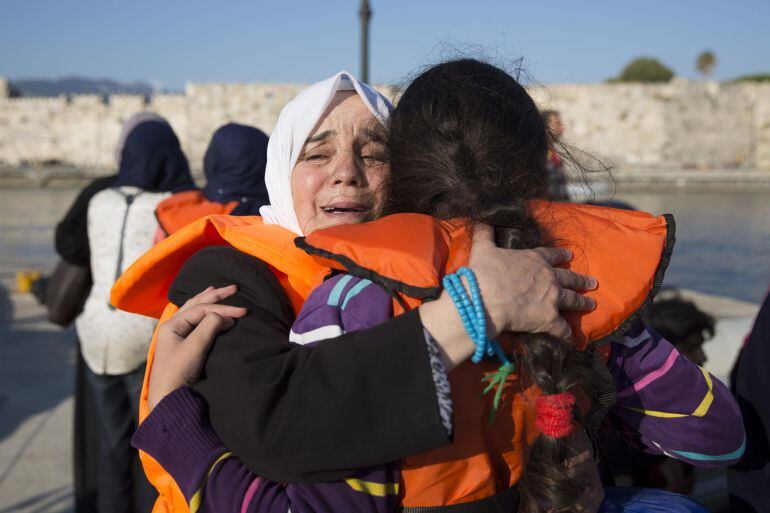 KOS, GREECE - AUGUST 30: A Syrian woman embraces a child after arriving on Kos in an inflatable dinghy on August 30, 2015 in Kos, Greece. Migrants from many parts of the Middle East and African nations continue to flood into Europe before heading from Ath