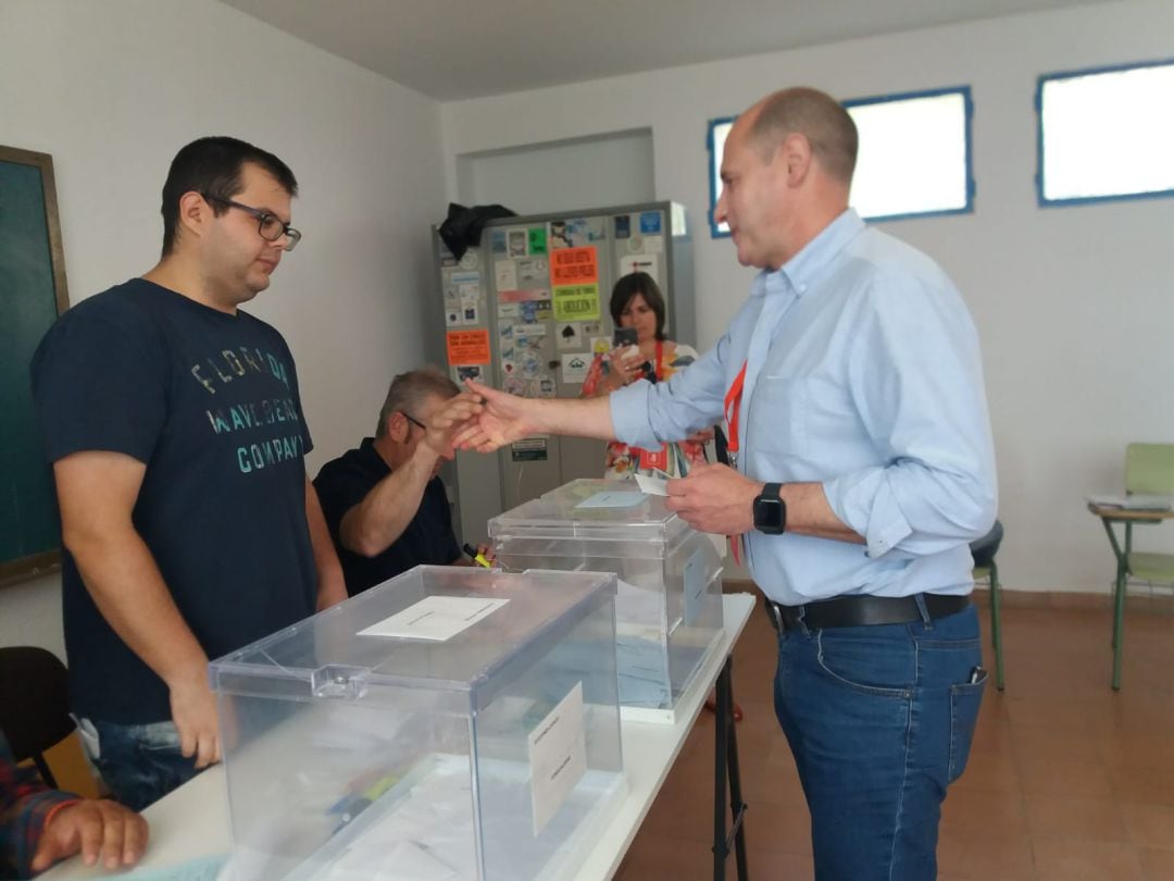 José Luis Hidalgo, candidato del PSOEm saluda a los miembros de la mesa electoral, al ejercer su derecho a voto