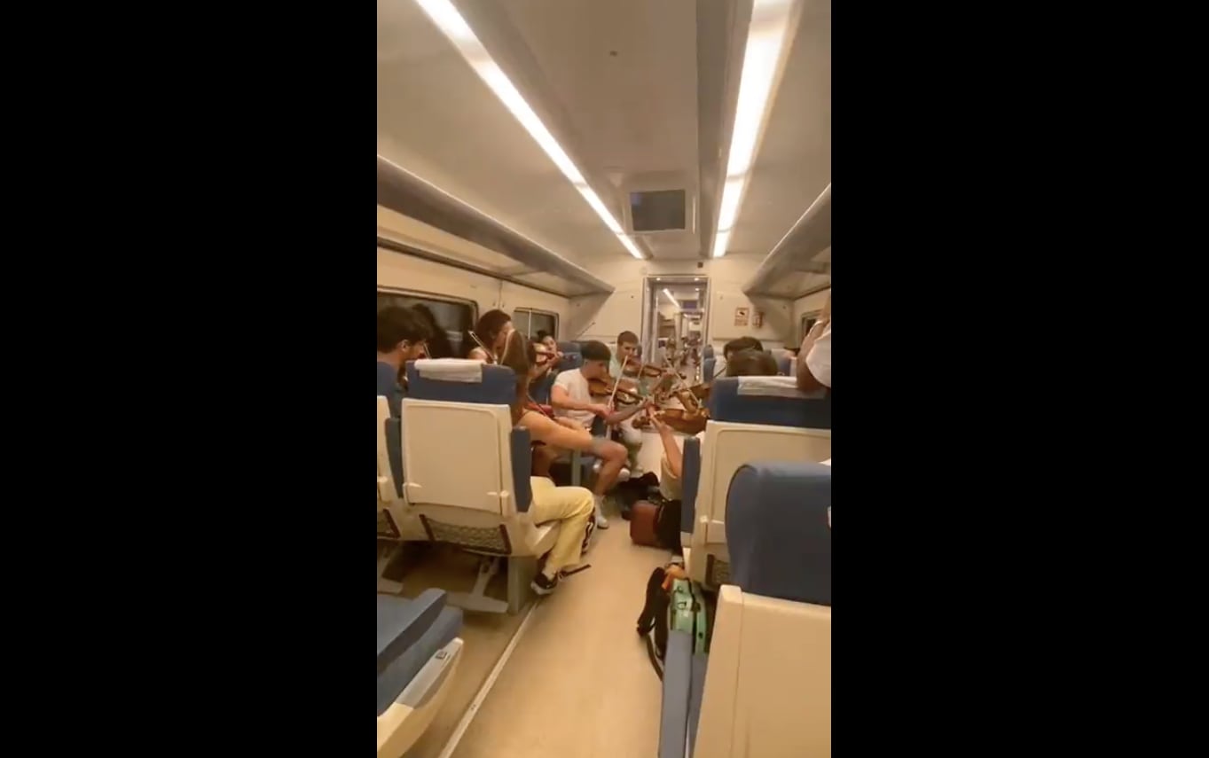 Jóvenes interpretan una pieza de música clásica en el tren Sevilla-Jaén.