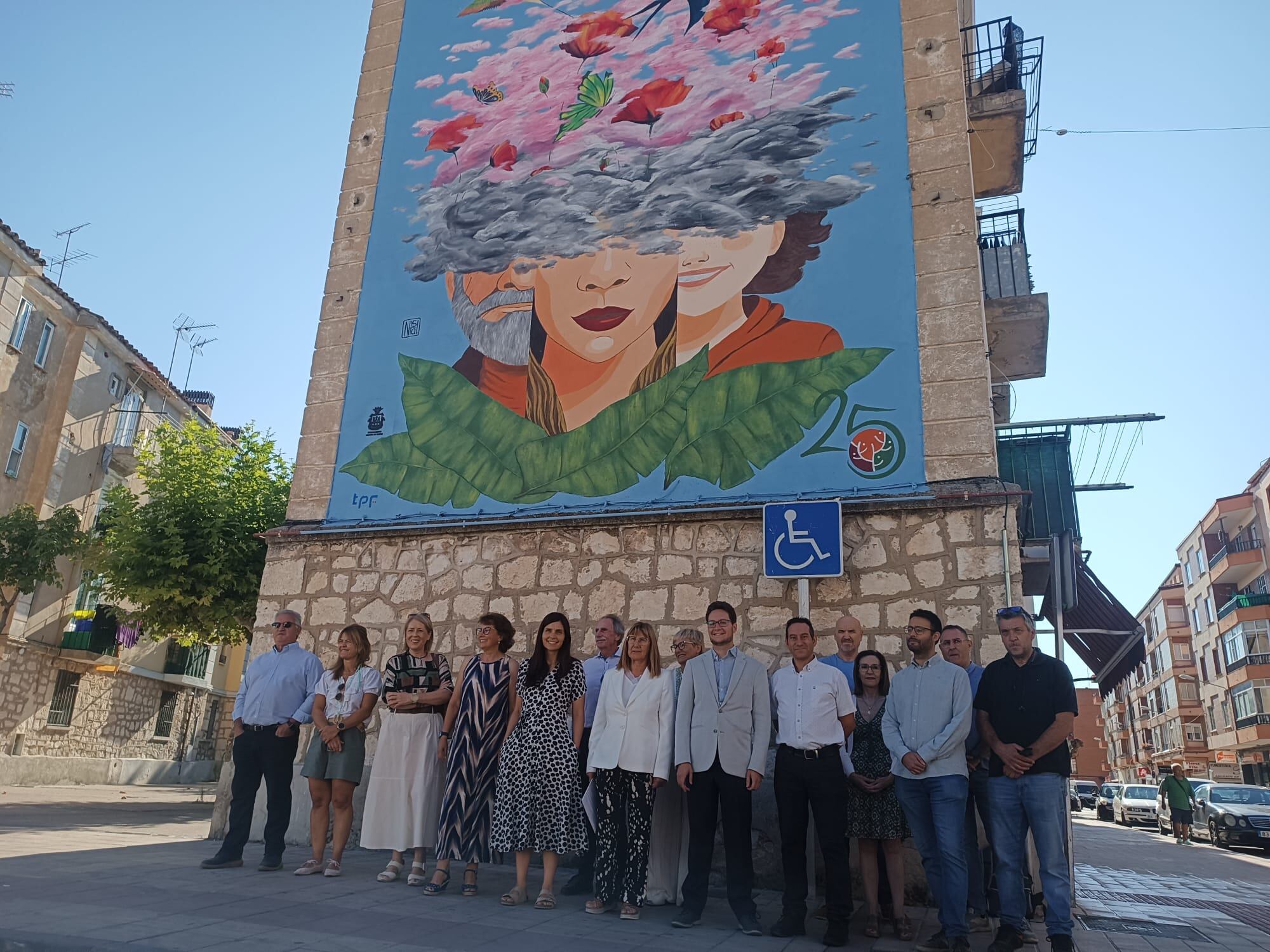 Las autoridades locales, representantes de Salud Mental Aranda y la autora del mural posan delante de la obra