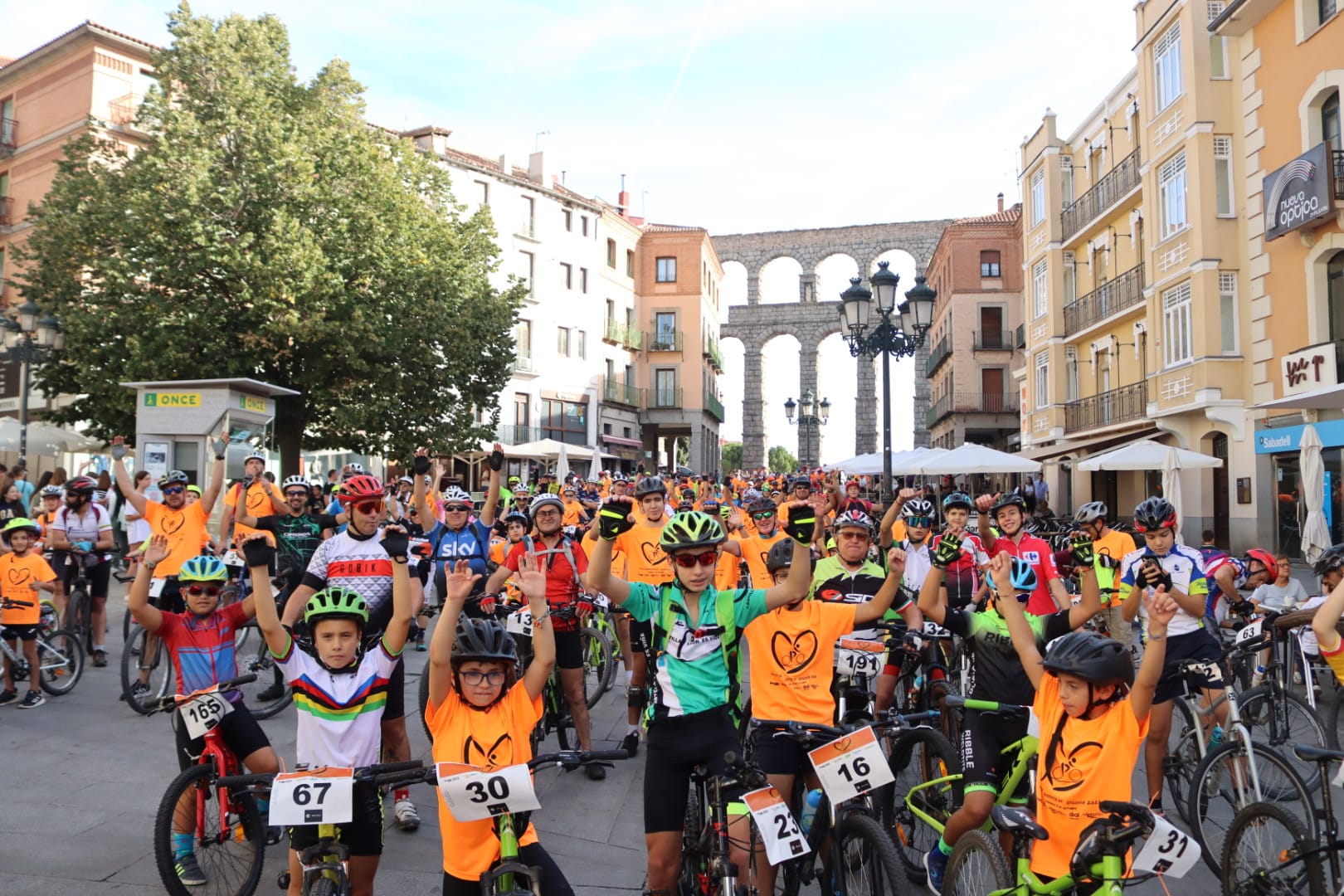 Algunos participantes en el Día de la Bicicleta de Radio Segovia con el acueducto de fondo