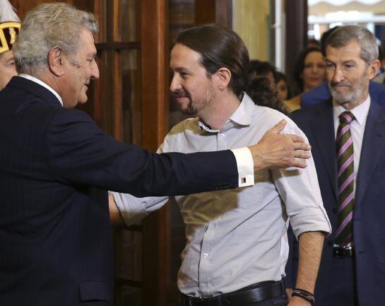 El presidente del Congreso, Jesús Posada (i), saluda al líder de Podemos, Pablo Iglesias (c), a su llegada a la recepción celebrada en Madrid con motivo del XXXVII aniversario de la Constitución. Tras Iglesias, el ex JEMAD y número dos de la formación por