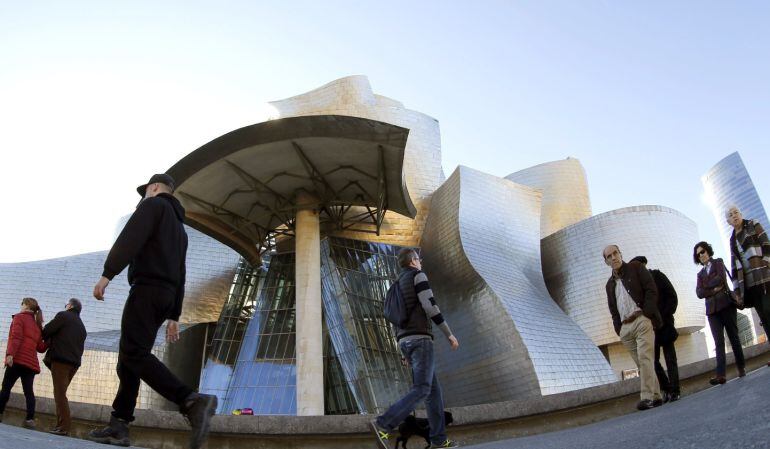 Numerosos paseantes y turistas pasean por las inmediaciones del Museo Guggenheim de Bilbao