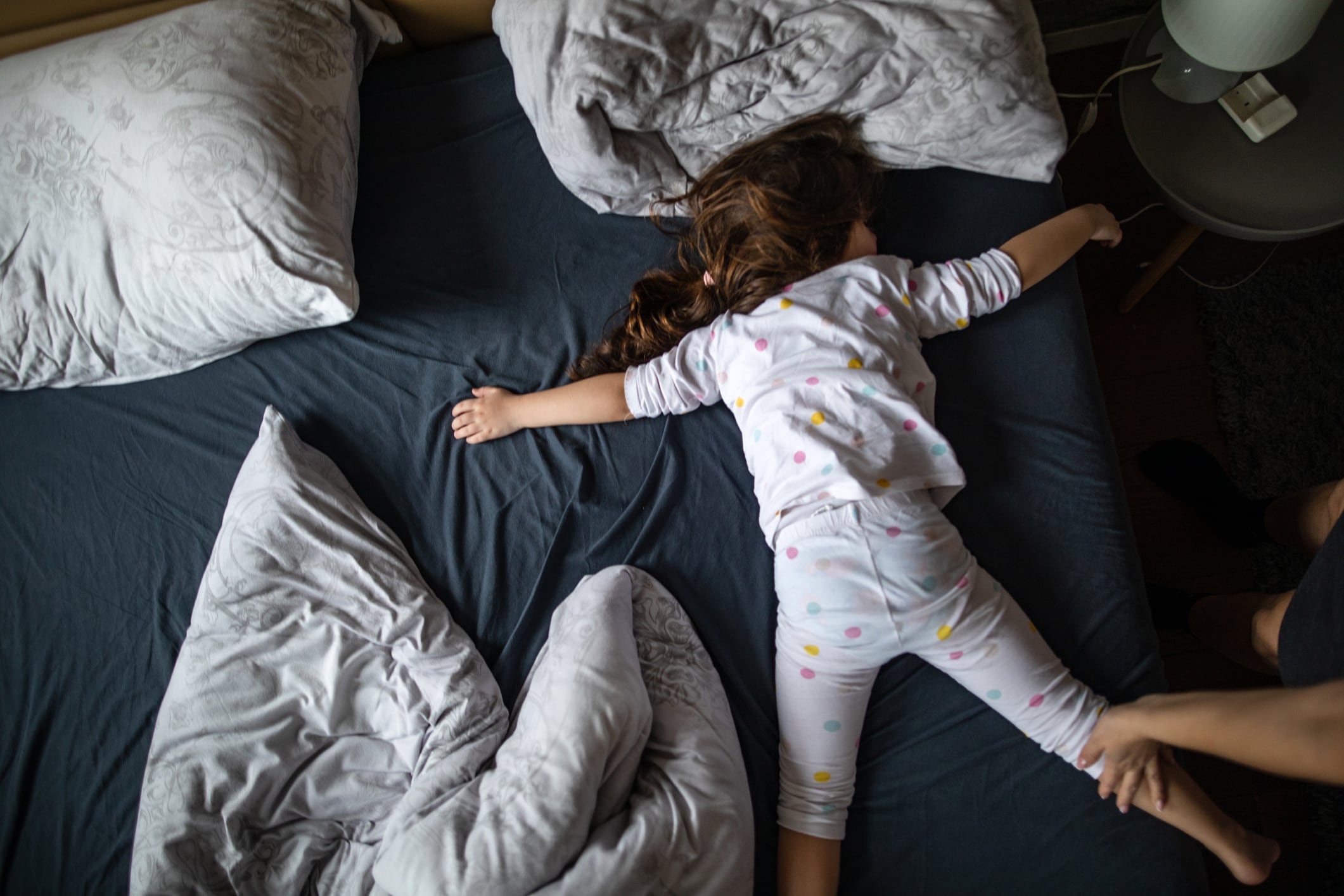 Una niña intenta dormir destapada en verano.