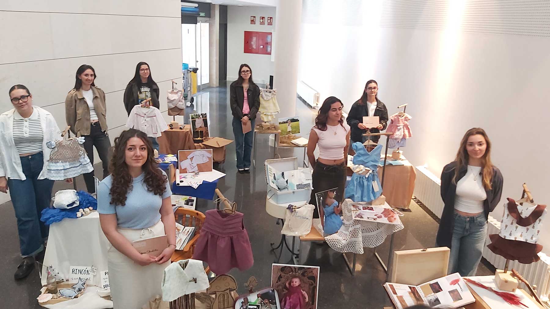 Las ocho alumnas junto a sus respectivos trabajos presentados