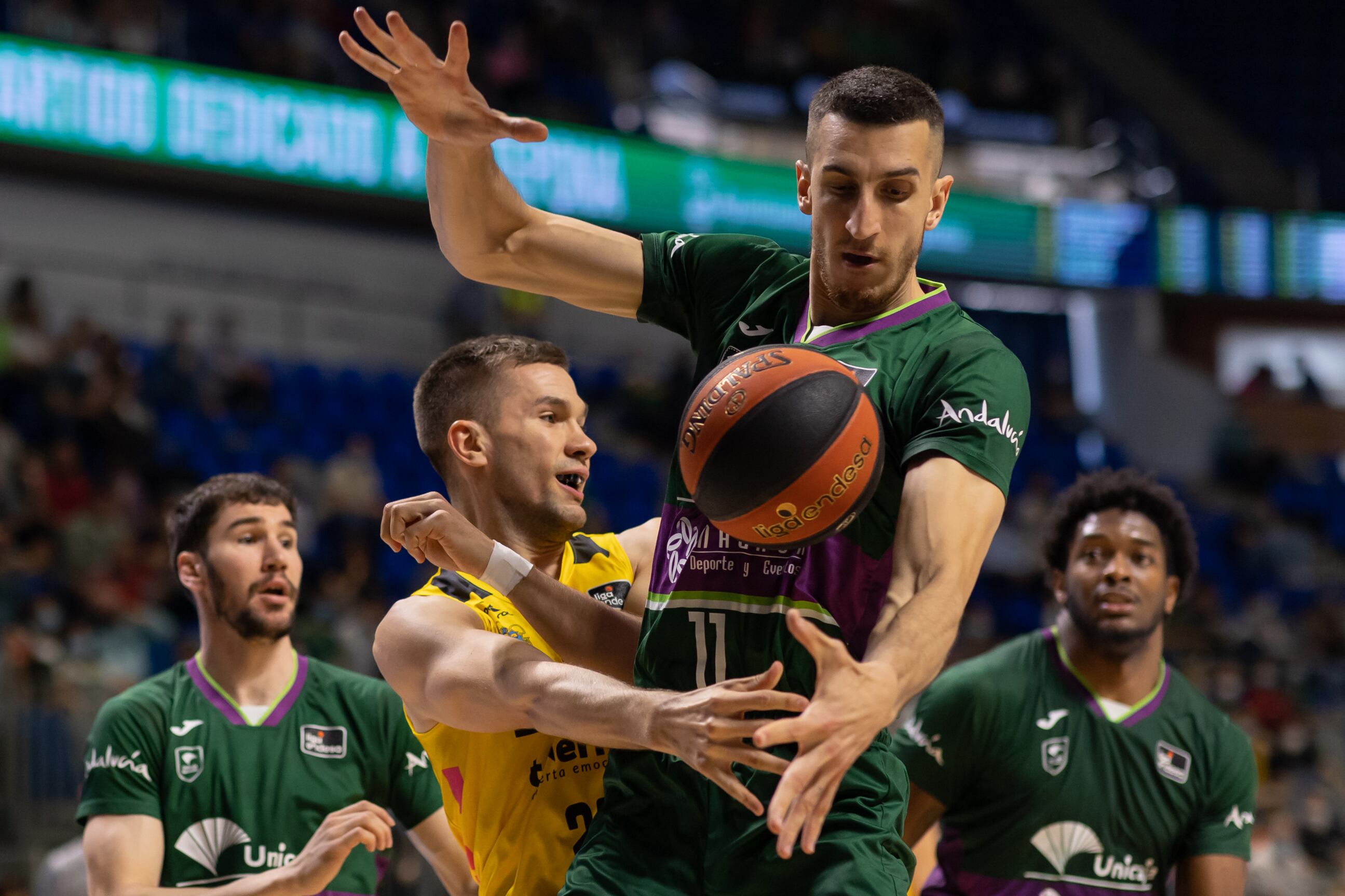 El pívot bosnio del Unicaja Dejan Kravic (2d) le roba el balón al pívot bosnio del Lenovo Tenerife Emir Sulejmanovic (2i) durante el partido de la vigésimo novena jornada de la Liga Endesa disputado este domingo en el Palacio de los Deportes José María Martín Carpena de Málaga. EFE/Carlos Díaz