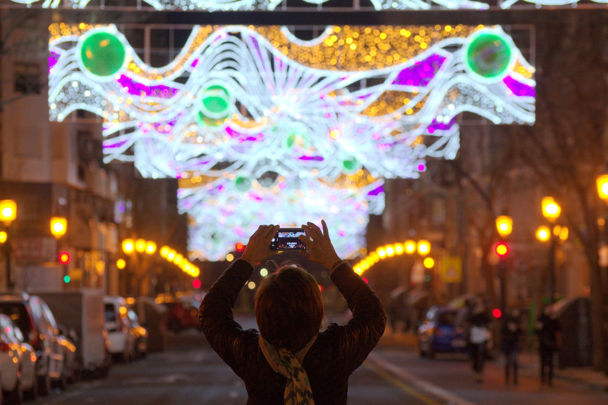 Una mujer tomando fotos a las luces durante las Fallas de Valencia