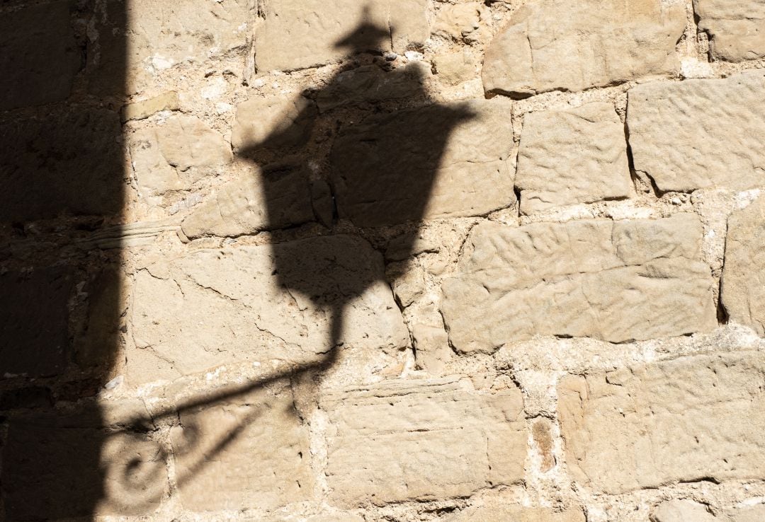 Sombra de un farol sobre una pared de piedra en Teruel (Aragón).