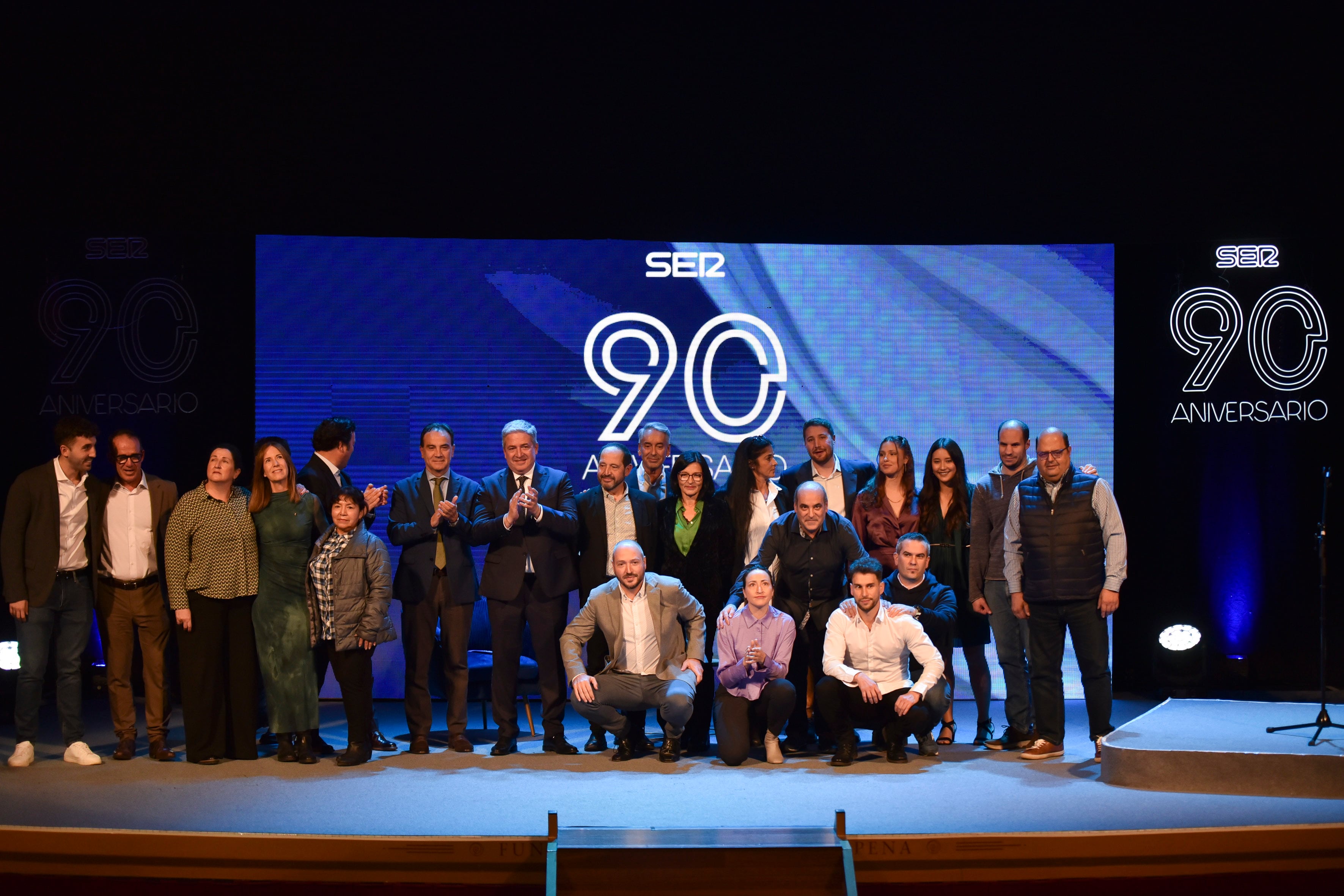 Buena parte de la plantilla de Radio Huesca-SER saludan al público asistente desde el escenario al acabar la Gala 90 Aniversario